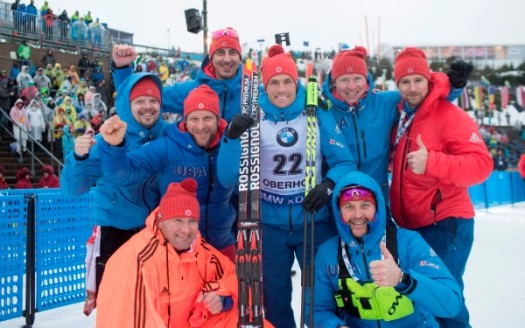 Tim Burke (center) celebrates his fourth-place finish in the men's 10-kilometer sprint with U.S. Biathlon coaches and staff [P] Nordic Focus