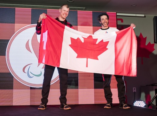 Brian McKeever (r) passes the flag to Mark Arendz, Canada's flag bearer for the closing ceremonies at the 2018 Winter Paralympic Games in Pyeongchang, Korea. [P] Dave Holland/Canadian Paralympic Committee